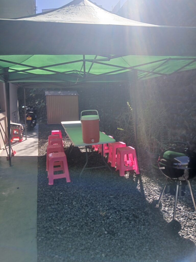 chapiteau vert, table blanche, tabouret rose et igloo orange installé